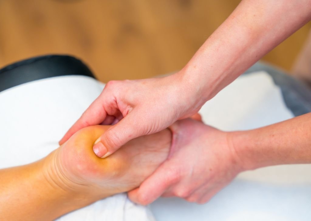 A patient getting massage on the foot for joint pain treatment.